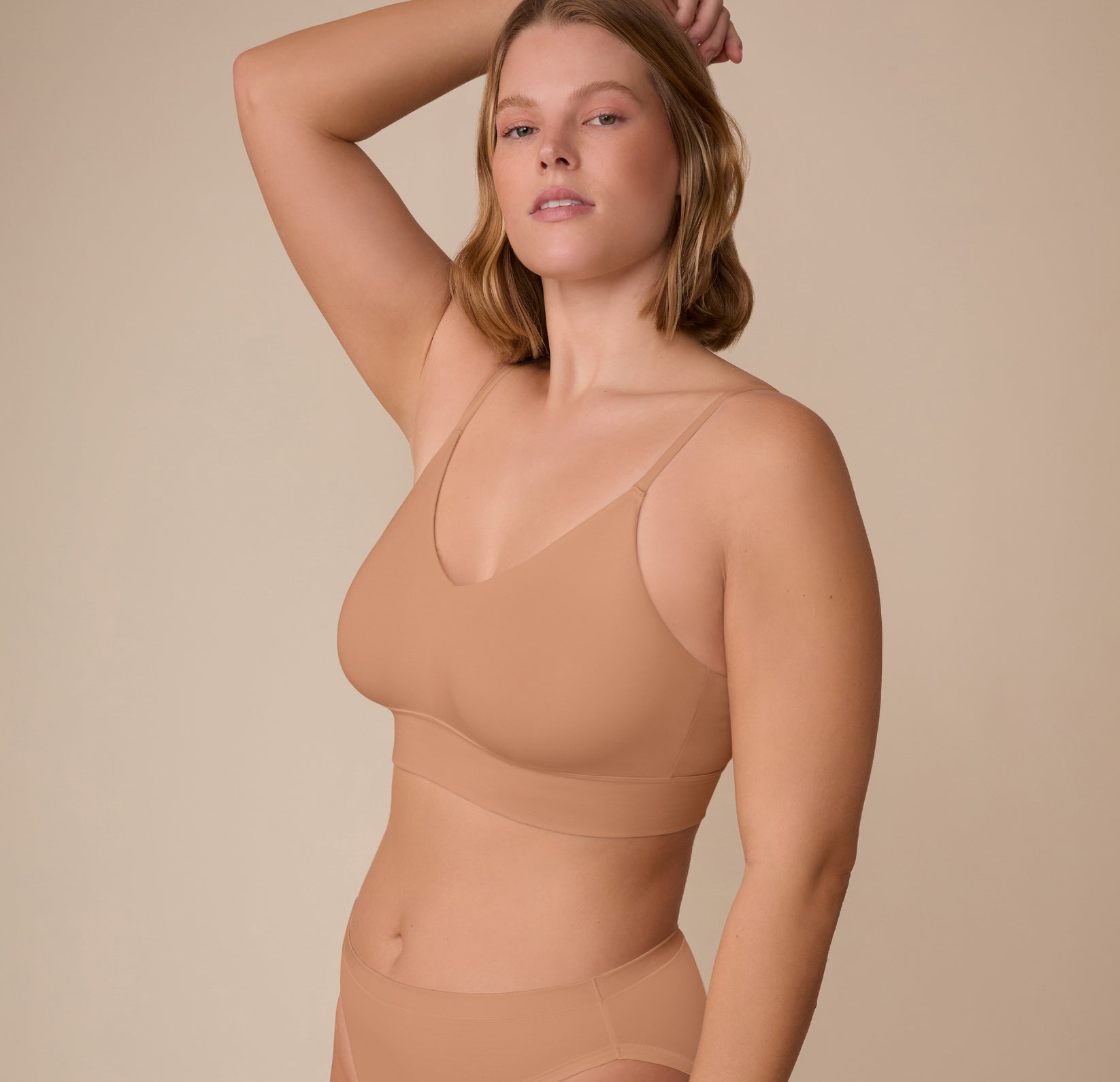 Three quarter view of Sonnie in the Cloud Cotton Triangle Bralette in Dune. The soft stretch fabric and clean seams are designed for barely-there comfort.