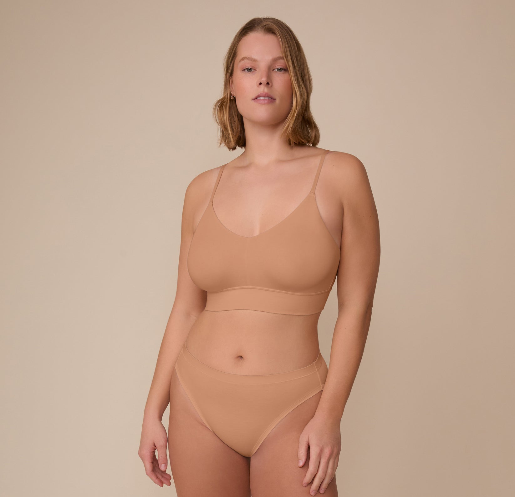 Full-body view of Sonnie in the Cloud Cotton Triangle Bralette and coordinating Cloud Cotton French Cut Brief in Dune. The look highlights a soft, minimal seam fit made to feel like a second skin.