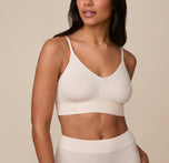 Close-up front view of model Nemesis wearing the Cloud Cotton Triangle Bralette in Quartz. The image highlights the bralette’s soft V-neckline, smooth finish, and wide underband designed for all-day comfort. sizing: Nemesis wears size Medium