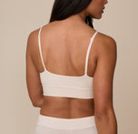 Back view of model Nemesis wearing the Cloud Cotton Triangle Bralette in Quartz. The image showcases the simple back design and adjustable straps for a customizable fit.
