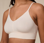 Close-up angled view of the Cloud Cotton Triangle Bralette in Quartz worn by model Nemesis. This shot emphasizes the soft fabric texture and minimal seaming for a barely-there feel.