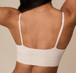 Close-up back view of Nemesis in the Cloud Cotton Triangle Bralette in Quartz, arms lifted. This angle highlights the stretchy back panel and how the straps adjust for a secure fit.