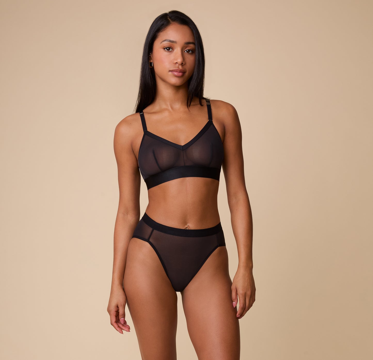Full-body view of a model wearing the ComfortMesh™ Highwaist Brief in Black paired with the matching Triangle Bralette. The high-rise fit and sheer detailing highlight a modern and supportive design.