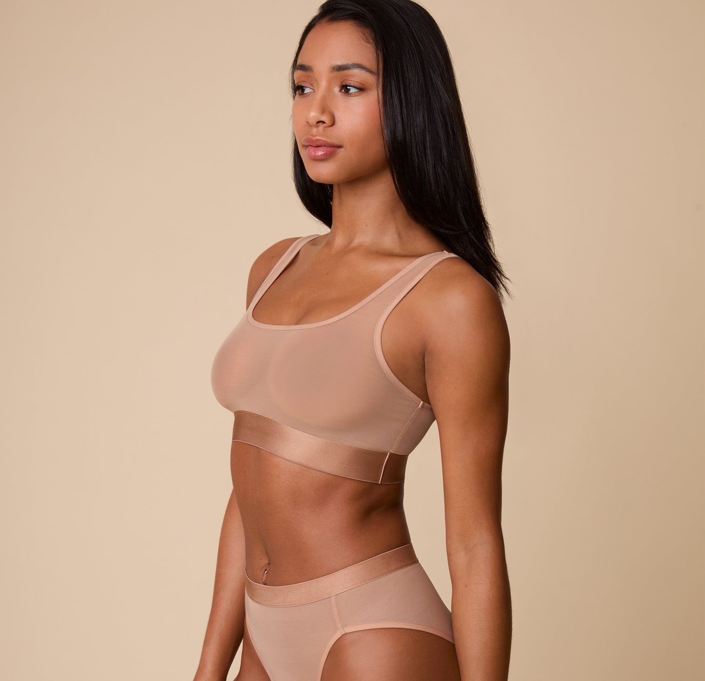 Three-quarter side view of Ally in the ComfortMesh™ Scoop Bralette in Taupe. The sheer fabric provides a flexible fit while maintaining support.