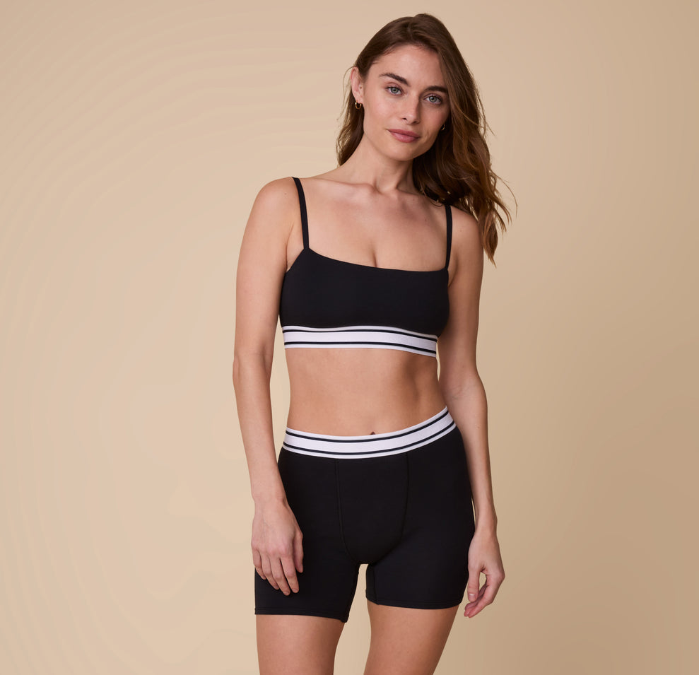 Full-body shot of Gracie wearing the Cloud Cotton Retro Boxer Brief in Black and matching Bandeau Bralette, standing in a relaxed pose against a neutral background.