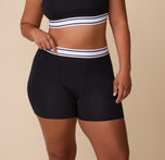 Close-up of India wearing the Cloud Cotton Retro Boxer Brief in Black, adjusting the waistband to showcase the flexible and comfortable fit. sizing: India wears size Large