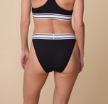 Back view of model Gracie in the Harper Wilde Cloud Cotton Retro French Cut Bikini in Black. The bikini provides moderate back coverage with a high-cut leg and a soft elastic waistband.