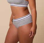 Side angle of India in the Cloud Cotton Retro Hiphugger in Heather Charcoal. The soft fabric and contrast waistband add a timeless, sporty vibe to the classic underwear style.
