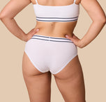 A back view of Emersyn wearing the Cloud Cotton Retro Hiphugger in White, displaying the no-dig waistband and comfortable design.