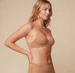 Side view of Megan wearing the Base Wirefree T-Shirt Bra in Tan, showcasing the smooth, wireless design and soft microfiber fabric.