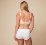 Back view of Megan in the Bliss Plunge Adjustable Bralette in Beige and Lounge Rib Boyshort in White, highlighting the adjustable back straps and soft, ribbed fabric of the boyshort for a relaxed, comfortable feel.