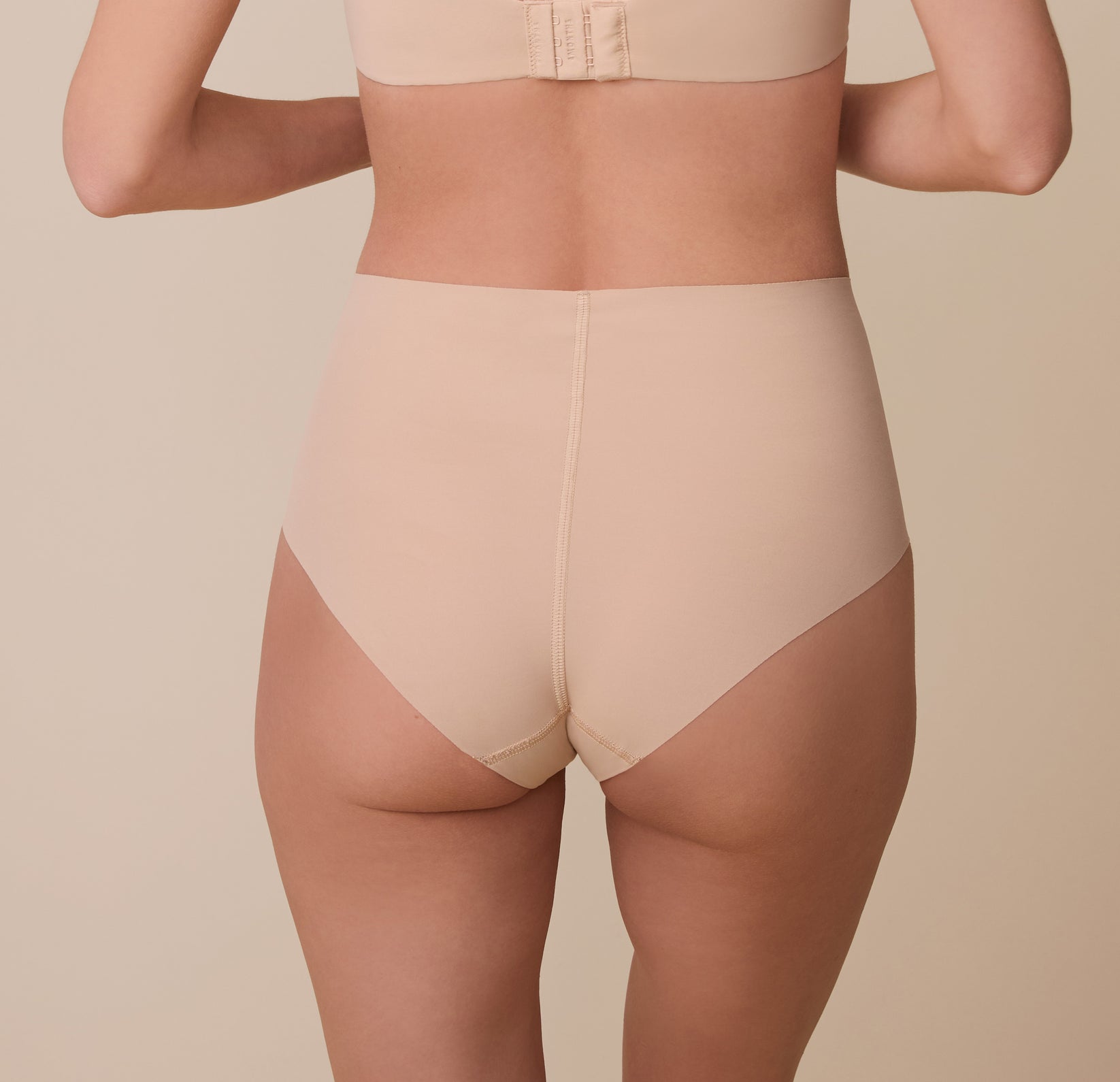 Gracie is shown from behind, highlighting the brief’s seamless construction and full-coverage back, which lays flat for an invisible look under clothing.