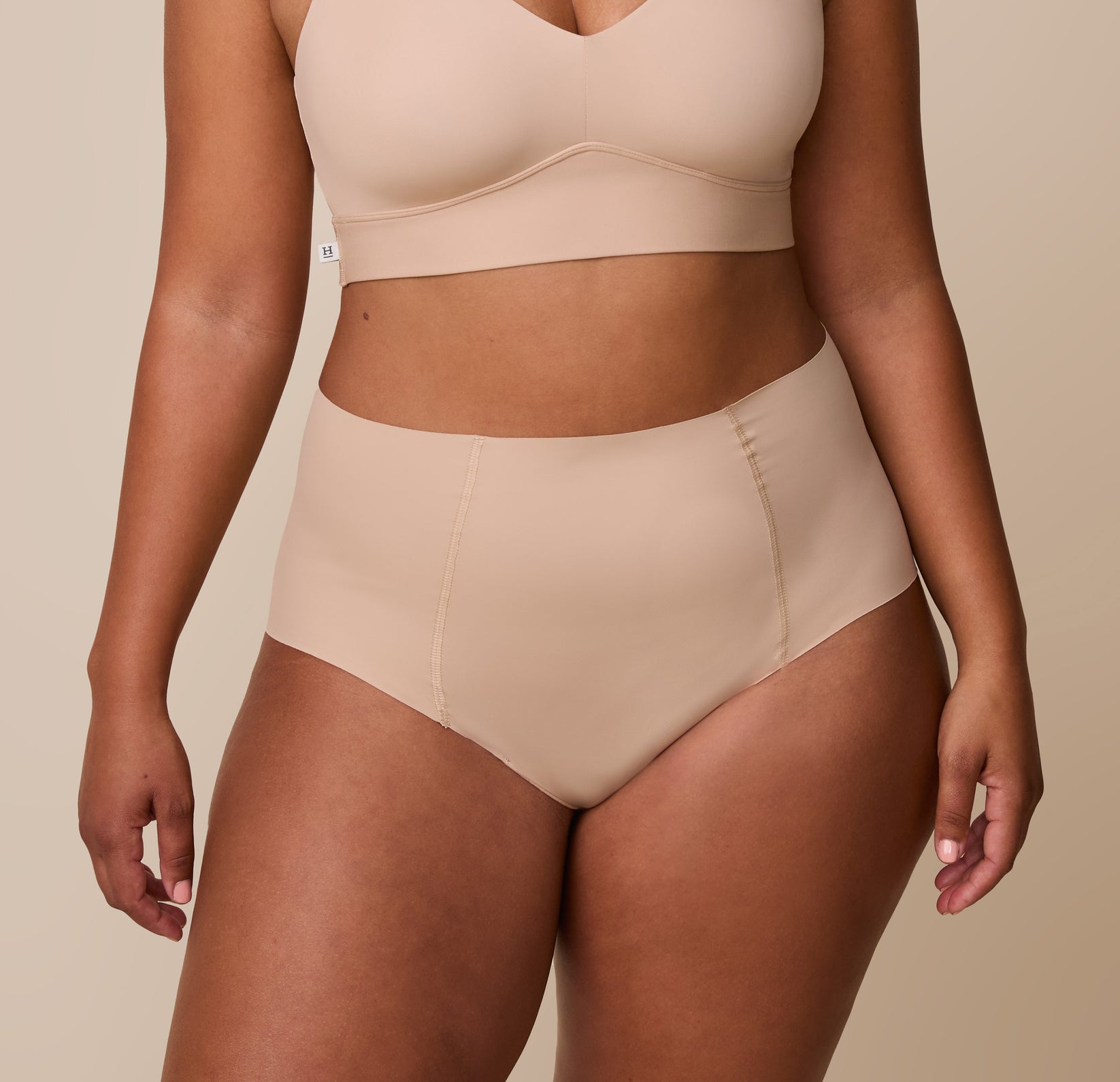 India wearing the No-Show Highwaist Brief in Beige, highlighting the smooth, sculpting fit with a matching Bliss Bralette for a coordinated set. sizing: India wears size Large