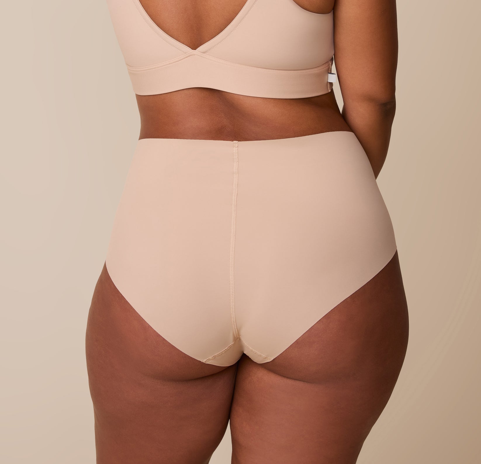 A back view of India in the No-Show Highwaist Brief, showing its seamless design and curve-hugging fit.