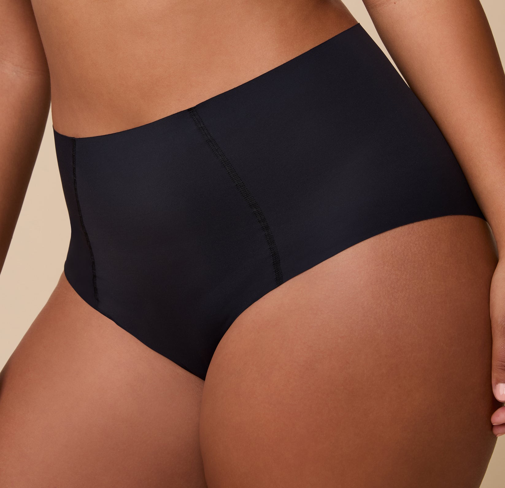 A close-up of the No-Show Highwaist Brief in Black, showcasing the raw-edge finish and lightweight, smoothing fabric.