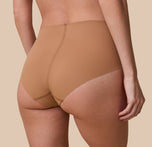 Gracie is shown from behind in a detailed, up-close shot, highlighting the brief’s full-coverage back and raw-cut edges that lay flat for a no-show look.