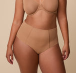 India wearing the No-Show Highwaist Brief in Tan, highlighting its sleek, second-skin fit and high-rise silhouette. sizing: India wears size Large