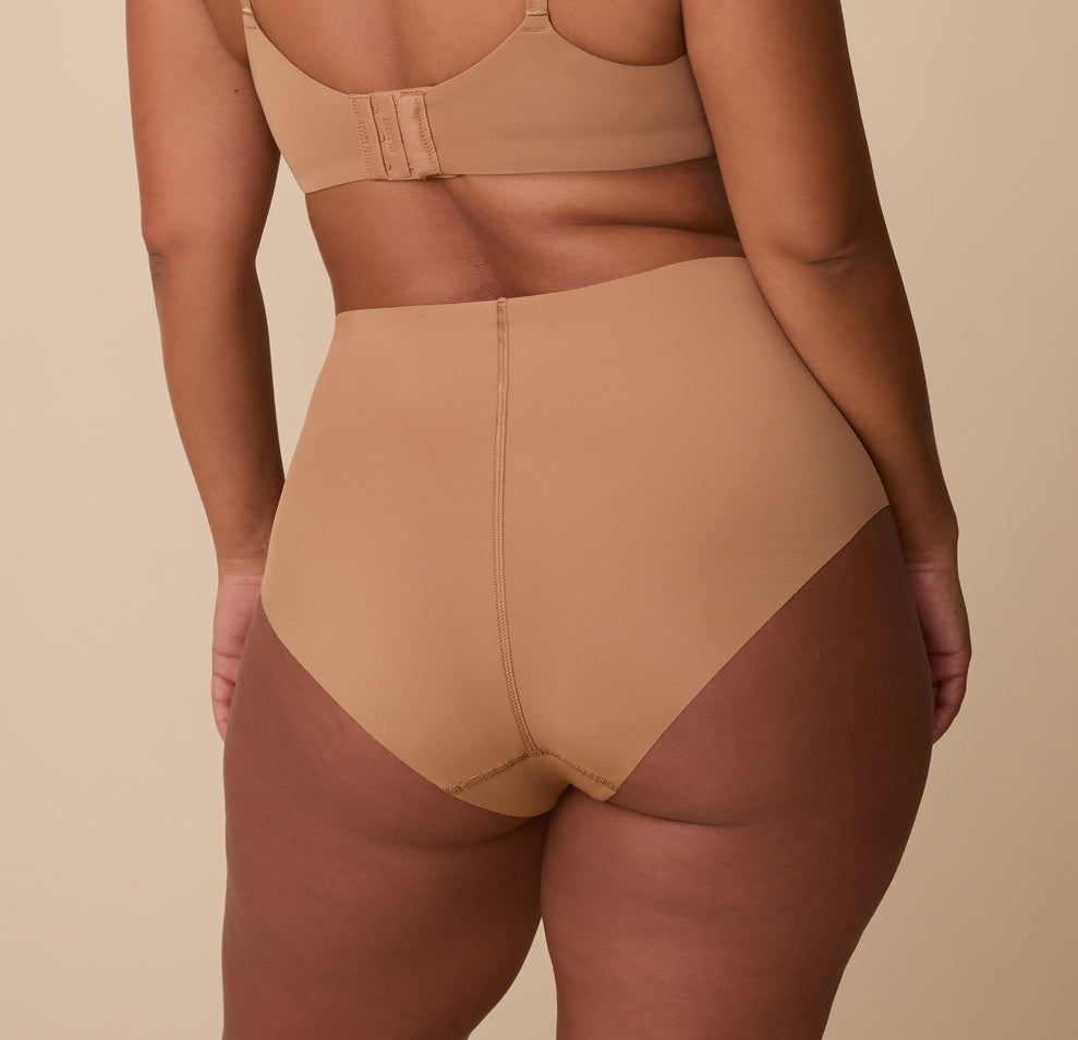 A back view of India in the No-Show Highwaist Brief, showing its seamless construction and sculpting fit.