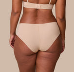 India is shown from behind, highlighting the full-coverage back and raw-cut edges of the No-Show Hiphugger in Beige for a sleek, no-show finish.
