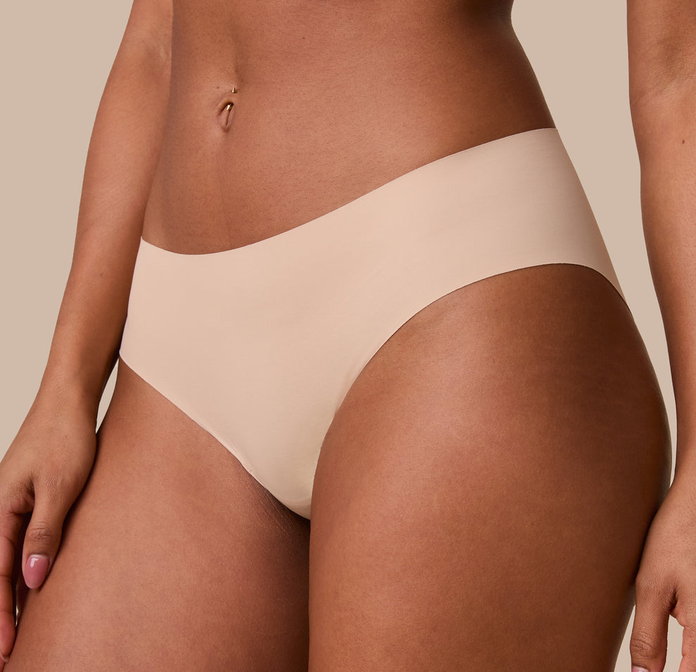 A close-up of Ally’s side profile in the No-Show Hiphugger in Beige, emphasizing the ultra-soft, invisible waistband.