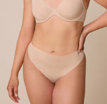 A detailed shot of the No-Show Thong in Beige on Emersyn, focusing on the barely-there waistband that lays smooth on the skin. sizing: Emersyn wears size Large