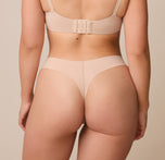 Back view of Emersyn in the No-Show Thong in Beige to showcase the soft, flexible fabric that moves with the body.