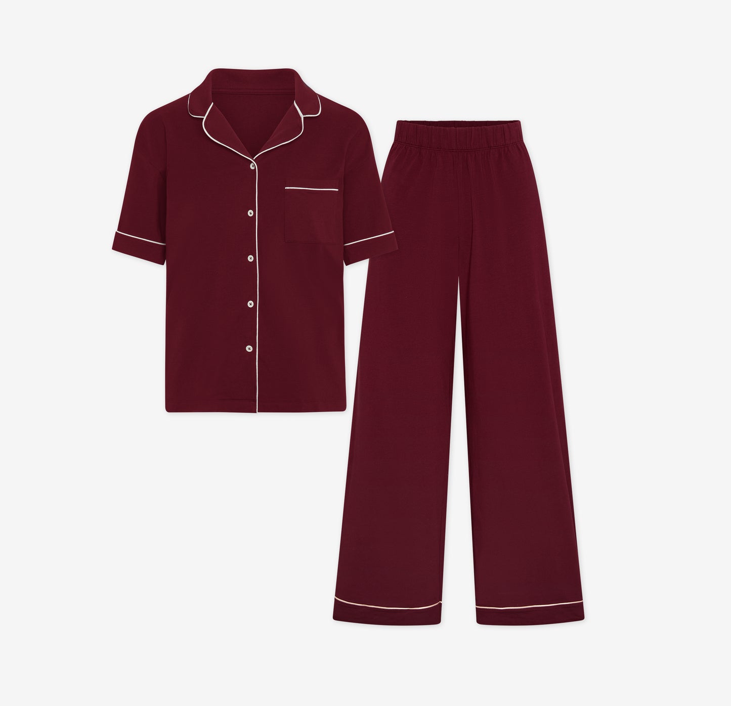 Harper Wilde Pima Pajama Set in Bordeaux. Includes short sleeve, button-up top with white piping and matching long pajama pants. Set laid flat on a white background.