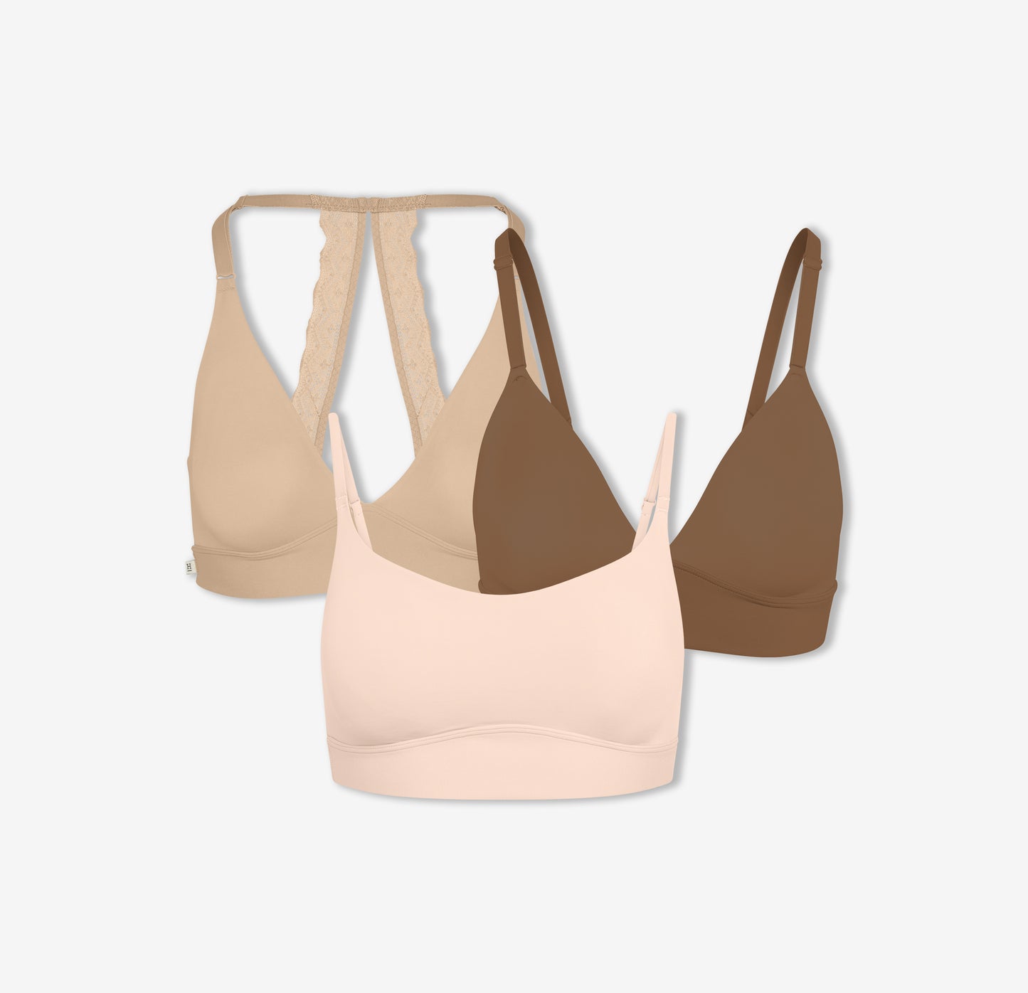 A trio of Harper Wilde Bliss Lace Halterneck Bralette in Beige, Bliss Triangle Bralette in Brown, and Bliss Scoop Bralette in Rose — offering wireless support and comfort.
