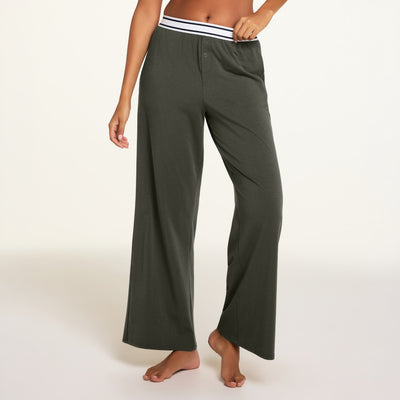 Hero close-up of the Cloud Cotton Pant in Olive, a relaxed straight-leg lounge pant in cloud-soft cotton-modal fabric with an elastic waistband and side pockets, paired with the Cloud Cotton Bandeau Bralette in Olive.