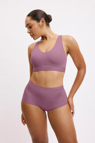 In a studio setting, Amber wears the Bliss Boyshort in Mirage with a matching bra, shown in a front-facing pose. The boyshort features a mid-rise fit, full coverage, and smooth, seamless fabric.