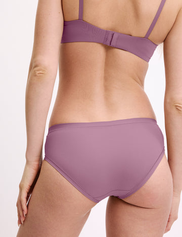 In a studio setting, a model wears the Bliss Hiphugger in Mirage, shown from the back. The hiphugger features a low-rise fit, moderate coverage, and smooth, seamless fabric.