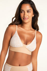 Front view of model wearing the Bliss Lace Highwaist Brief in Beige with a smooth beige front panel and white geometric fan lace side panels, paired with the Bliss Lace Bralette in Beige with white lace cups and a smooth beige underband, on a white studio background. sizing: Kushi wears size XS