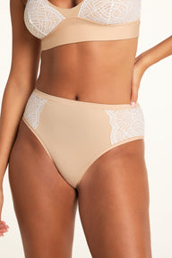 In a bright studio, Kushi wears the Bliss Lace Bralette and Bliss Lace Highwaist Brief in Beige, showing the bralette’s V-neck lace trim and the brief’s high-waisted silhouette with lace panels. sizing: Kushi wears size XS