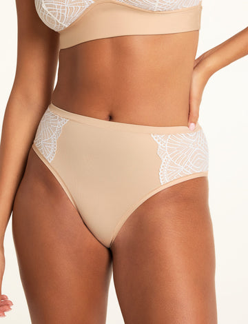 In a bright studio, Kushi wears the Bliss Lace Bralette and Bliss Lace Highwaist Brief in Beige, showing the bralette’s V-neck lace trim and the brief’s high-waisted silhouette with lace panels. sizing: Kushi wears size XS