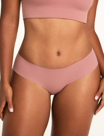 On a white studio backdrop, Amber wears the WhippedKnit Scoop and No-Show Hiphugger in Plum, shown in a close-up front view. sizing: Amber wears size Large
