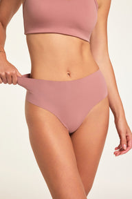 In a studio setting, Holly wears the Whipped Knit V-Neck in Plum and No-Show Highwaist Thong in Plum, pulling the thong waistband to show its stretch. sizing: Holly wears size Small 
