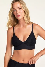 On a warm white studio backdrop, Holly wears the Bliss Lace Bralette in Black and Bliss Lace Highwaist Brief in Black, showing the V-neck bralette and lace detailing along the brief. sizing: Holly wears size Small