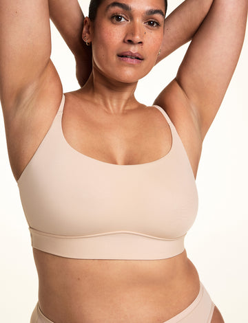Close-up front view of the Bliss Thin-Strap Scoop Bralette in Beige. sizing: Jennifer wears size XL