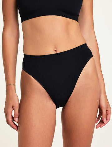 Front on-model shot of the Knit Seamless French Cut Brief in Black paired with the Knit Seamless Bralette in Black. sizing: Holly wears size Small