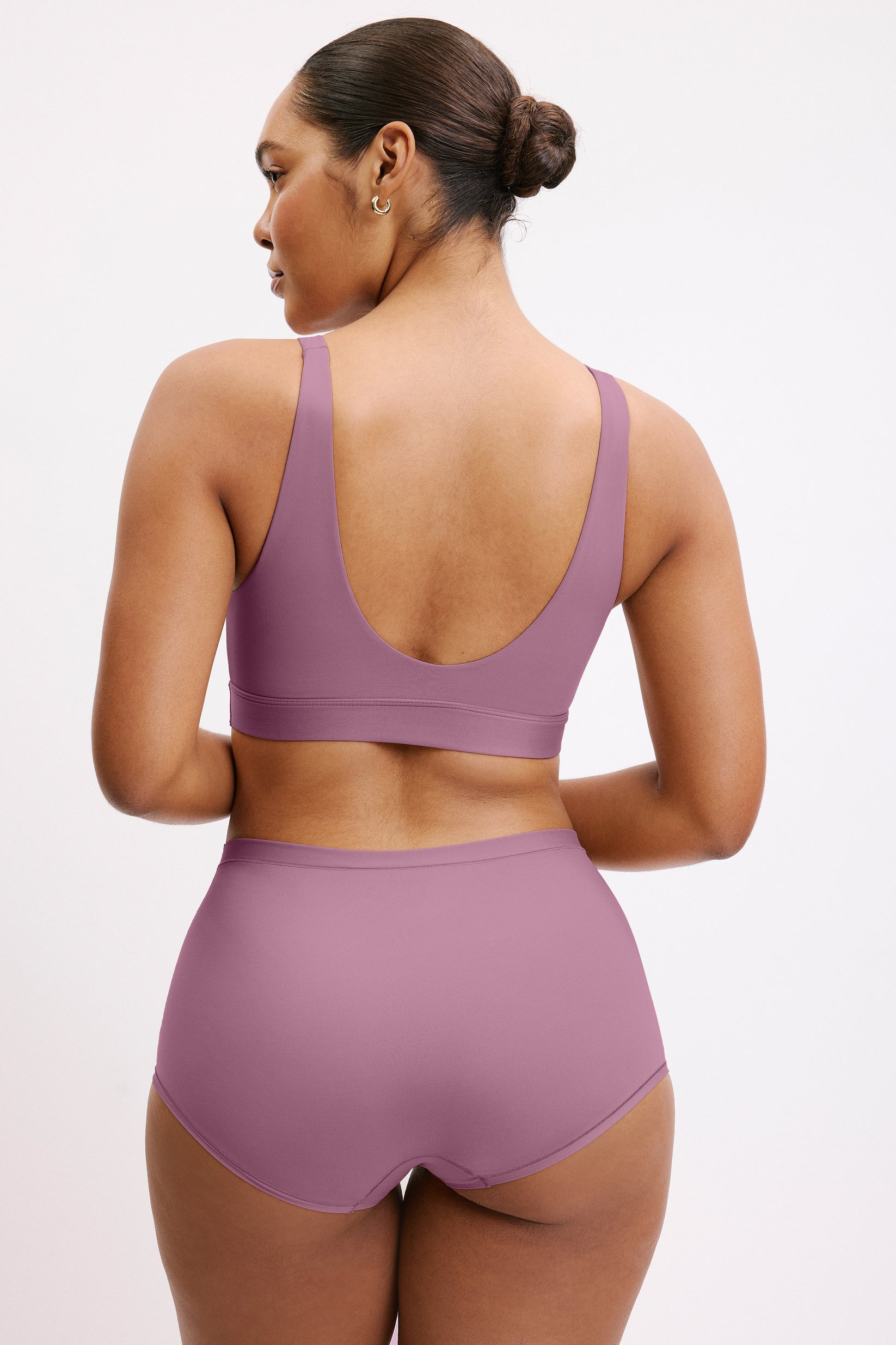 In a studio setting, Amber wears the Bliss Boyshort in Mirage, shown from the back. The boyshort features full coverage with a smooth, seamless finish and clean edges.