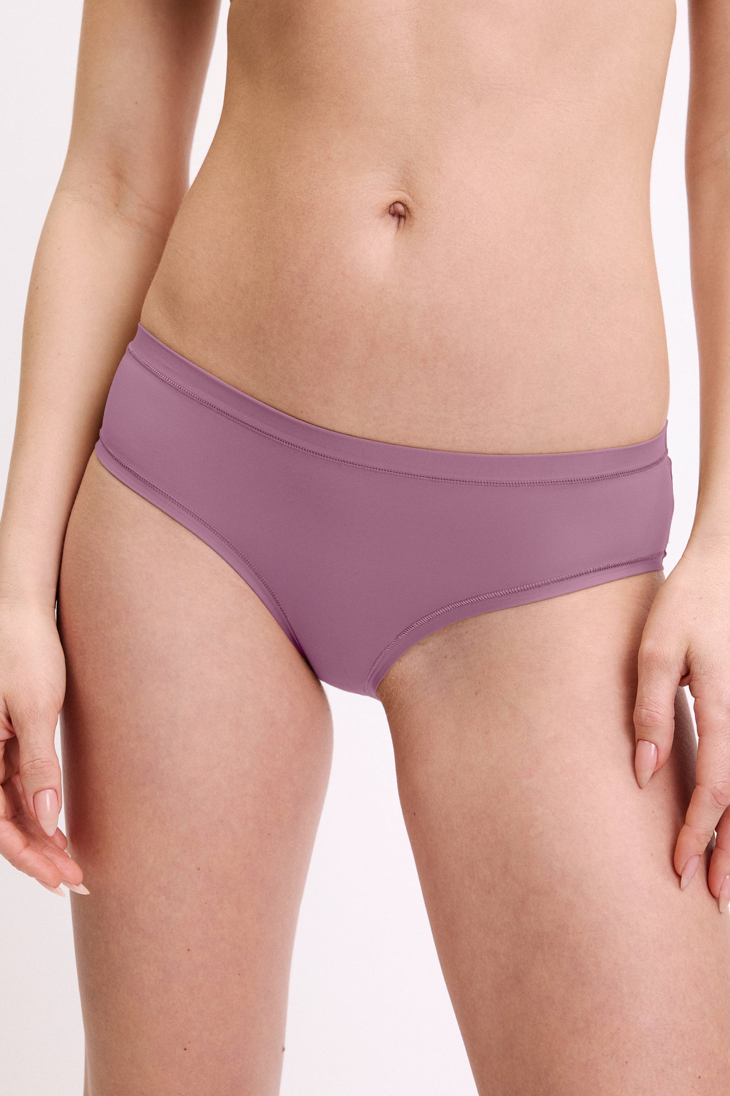 In a studio setting, a model wears the Bliss Hiphugger in Mirage, shown in a close-up front view. The hiphugger features a low-rise fit, moderate coverage, and smooth, seamless fabric. sizing: Megan wears size Small