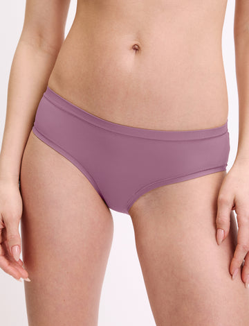 In a studio setting, a model wears the Bliss Hiphugger in Mirage, shown in a close-up front view. The hiphugger features a low-rise fit, moderate coverage, and smooth, seamless fabric. sizing: Megan wears size Small