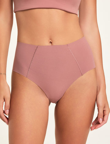 In a studio setting, Holly wears the Whipped Knit No-Show Highwaist Brief in Plum, shown in a close-up front view to highlight the high-waisted cut and angled seam details.