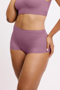 In a studio setting, Amber wears the Bliss Boyshort in Mirage, shown in an angled front view. The design features a mid-rise fit, full coverage, and smooth, seamless fabric. sizing: Amber wears size Large