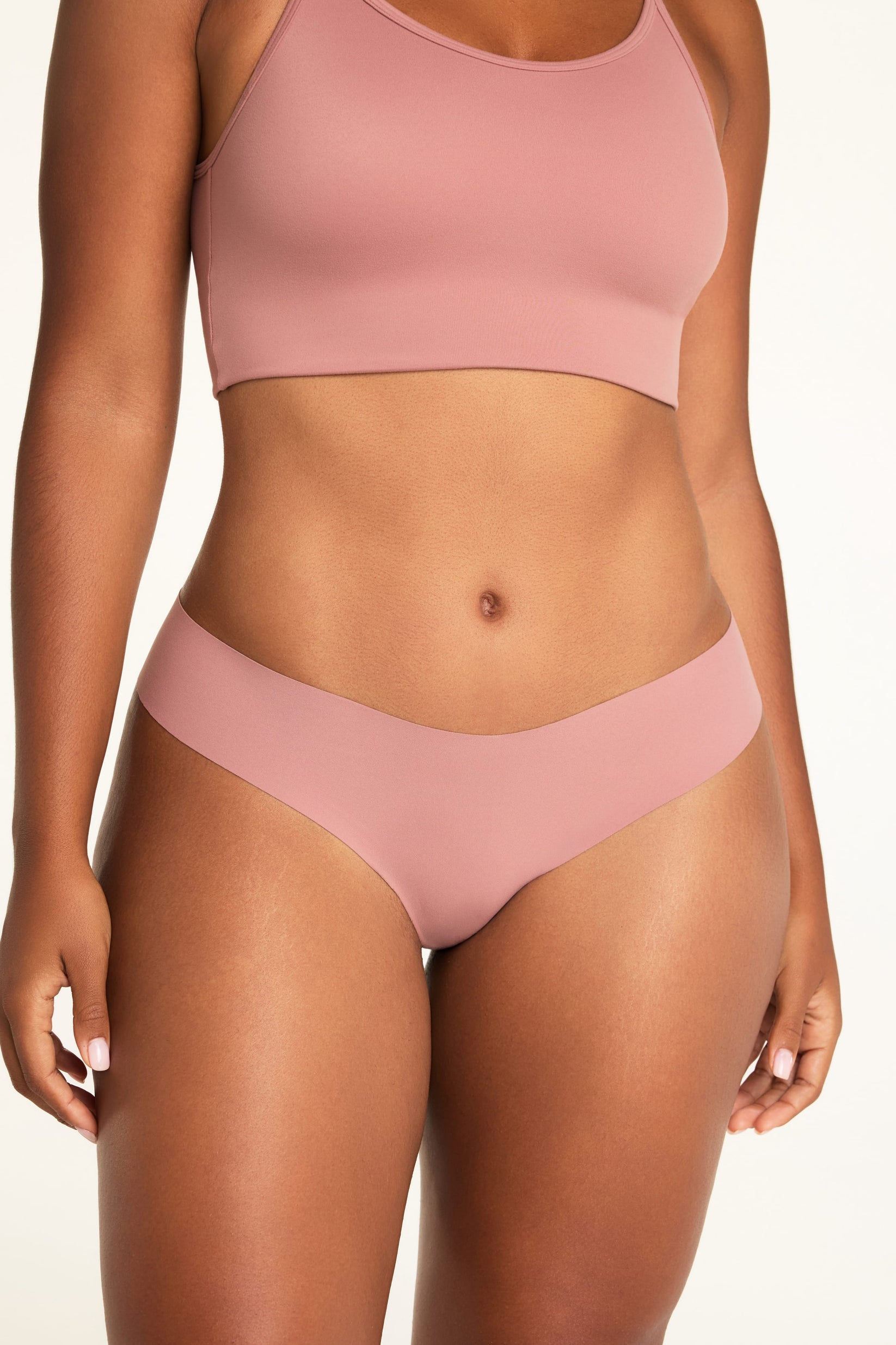 On a white studio backdrop, Amber wears the Whipped Knit Scoop and No-Show Low-Rise Thong in Plum, showing the scoop neckline, slim straps, and low-rise waistband.
