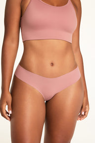 On a white studio backdrop, Amber wears the Whipped Knit Scoop and No-Show Low-Rise Thong in Plum, showing the scoop neckline, slim straps, and low-rise waistband.