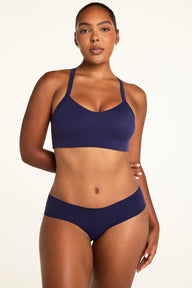 On a light studio backdrop, Amber wears the WhippedKnit V-Neck and No-Show Hiphugger, both in Noir, showing the V-neck top and smooth hiphugger with moderate back coverage.