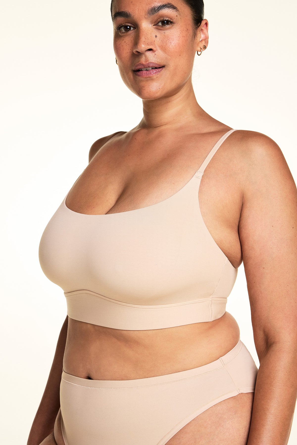 Three-quarter front view of the Bliss Thin-Strap Scoop Bralette in Beige.