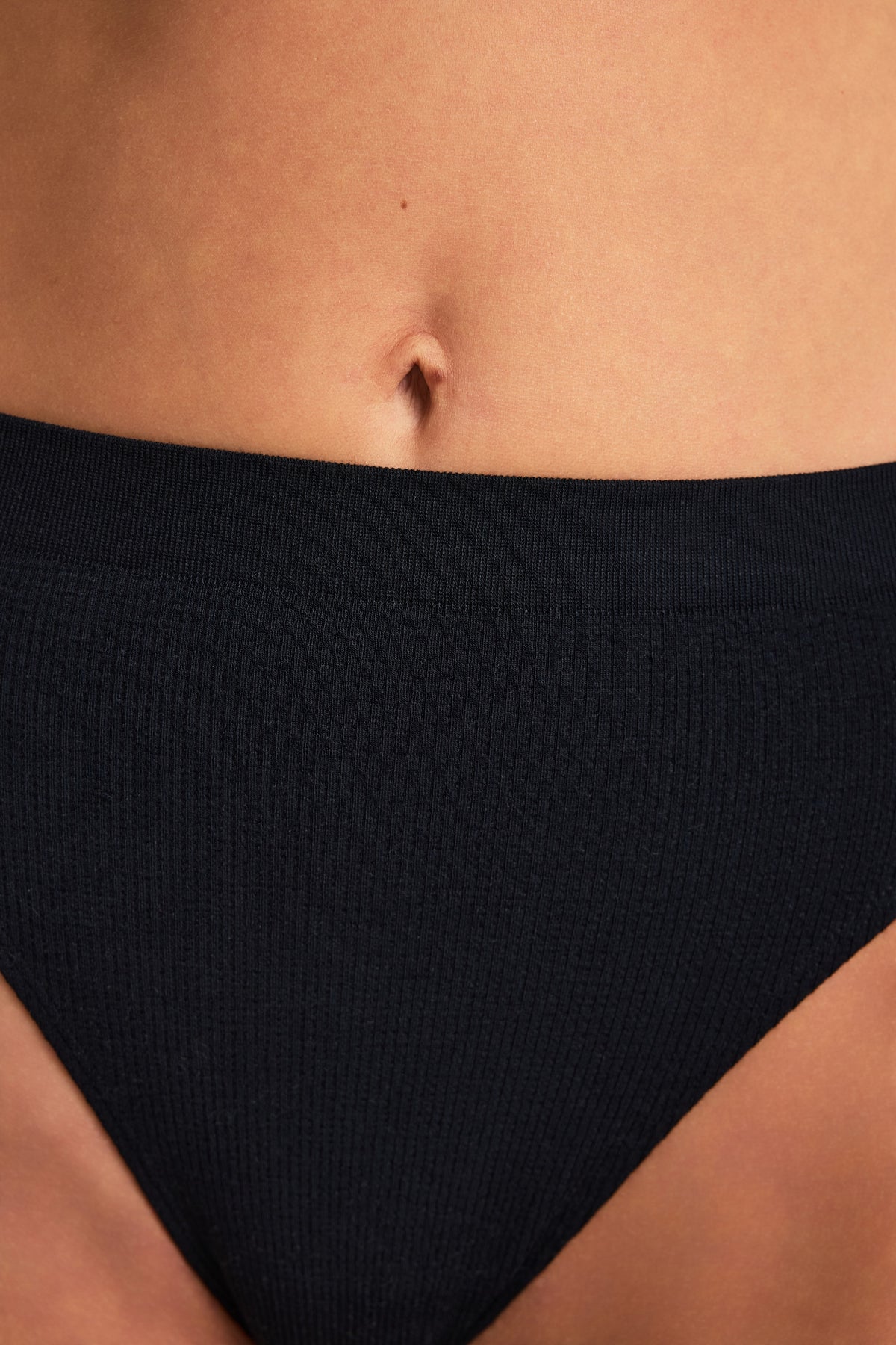 Back on-model view of the Knit Seamless French Cut Brief in Black paired with the Knit Seamless Bralette in Bralette.