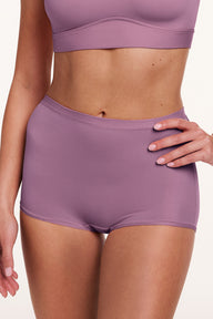 In a studio setting, Amber wears the Bliss Boyshort in Mirage, shown in a close-up front view. The boyshort features a mid-rise waistband and smooth, seamless construction for a streamlined look.
